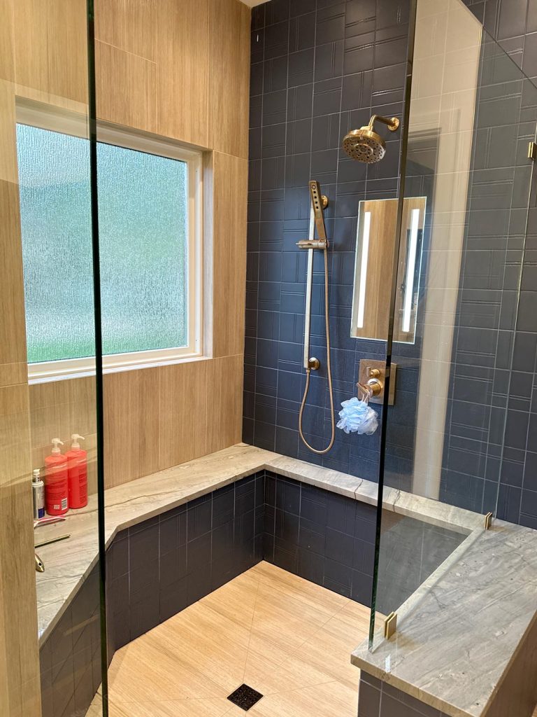 A luxury bathroom design in a home remodeling project with a custom tile walk-in shower.