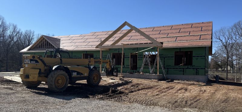 The roofing installation and exterior weather protection wrap for a custom home builder project.
